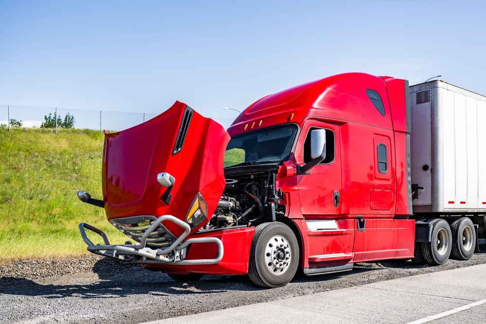 Red Semi-truck broken down by the side of the road